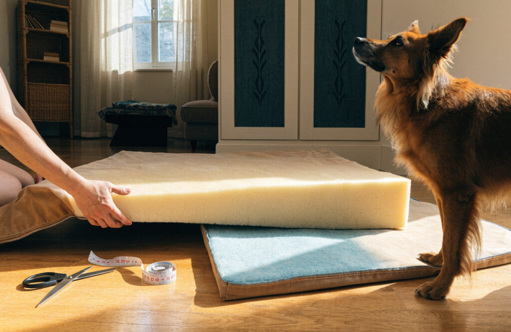 Thick foam slab being slid into a removable zippered canvas cover for a DIY dog bed