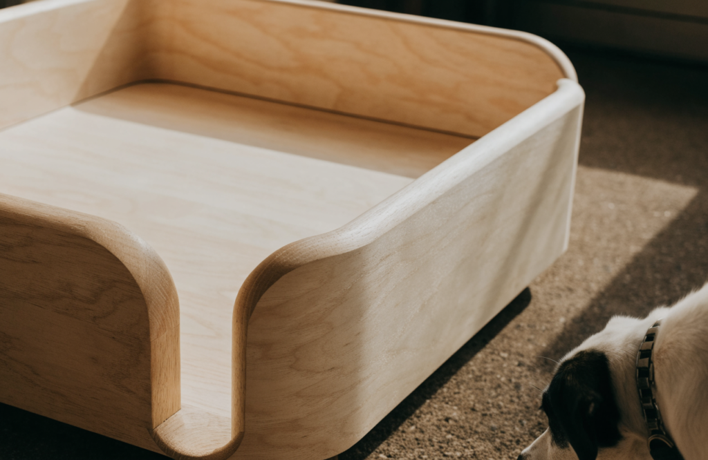 Sanded birch dog bed frame with rounded edges and a clear finish