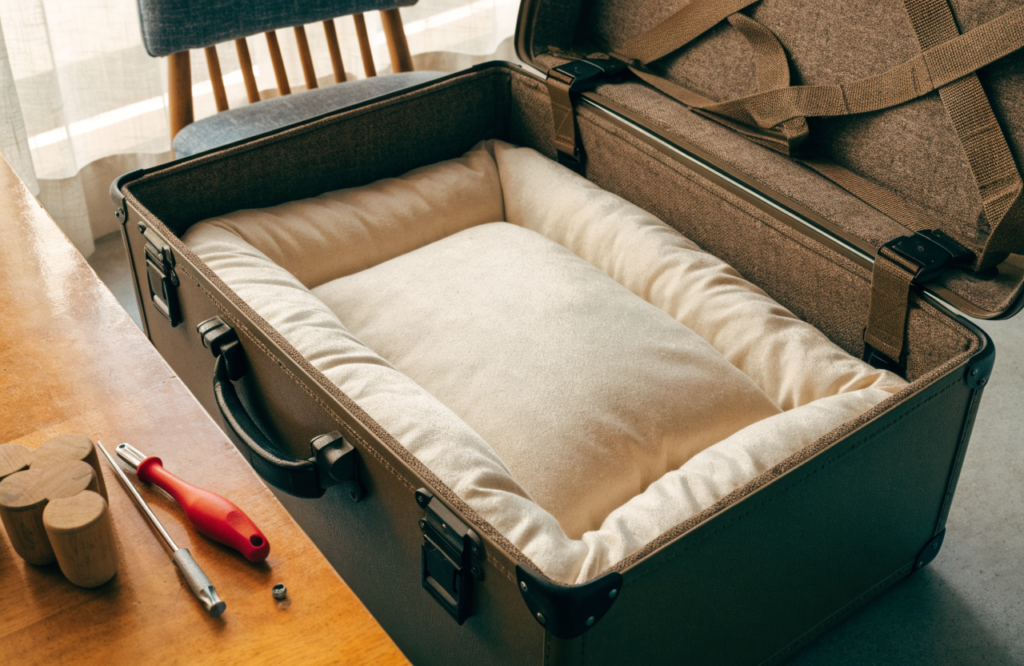 Cushion fitted inside an open hard-shell suitcase to make a dog bed