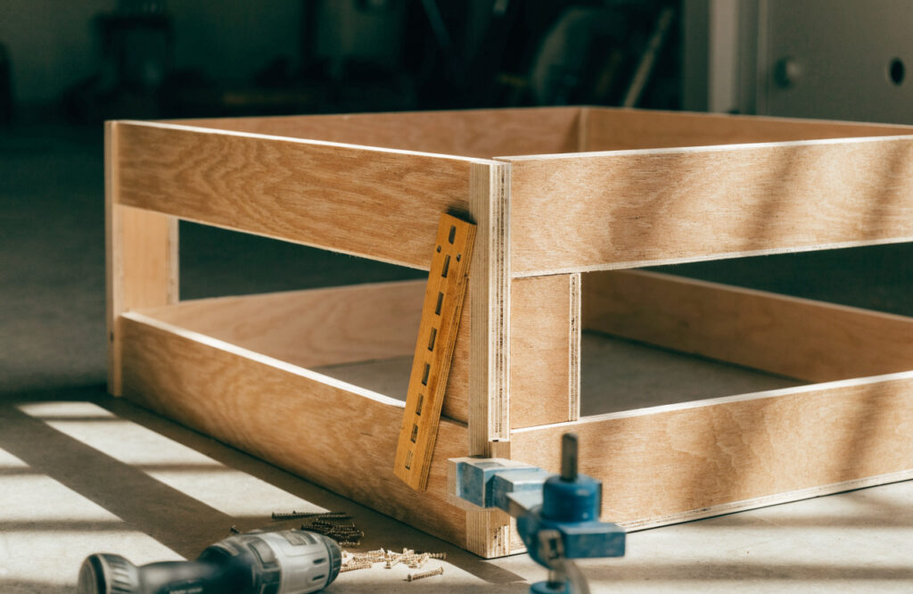 Speed square checking a corner of a clamped wooden dog bed frame